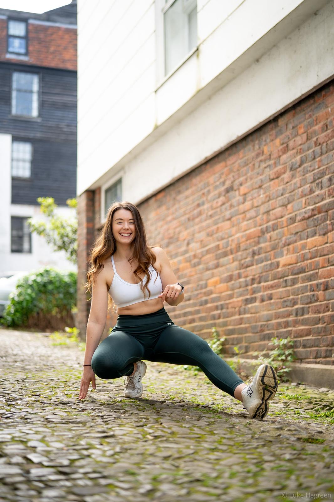 Emily Witney stretching outdoors in fitness clothing